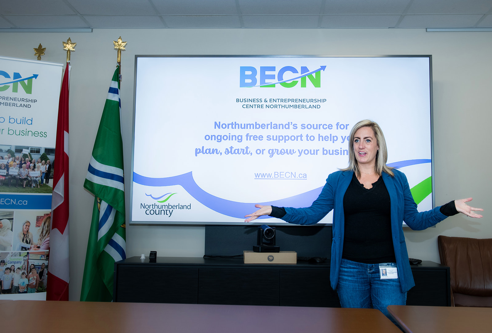 BECN staff member standing in front a of a PowerPoint presentation with their arms outstretched.