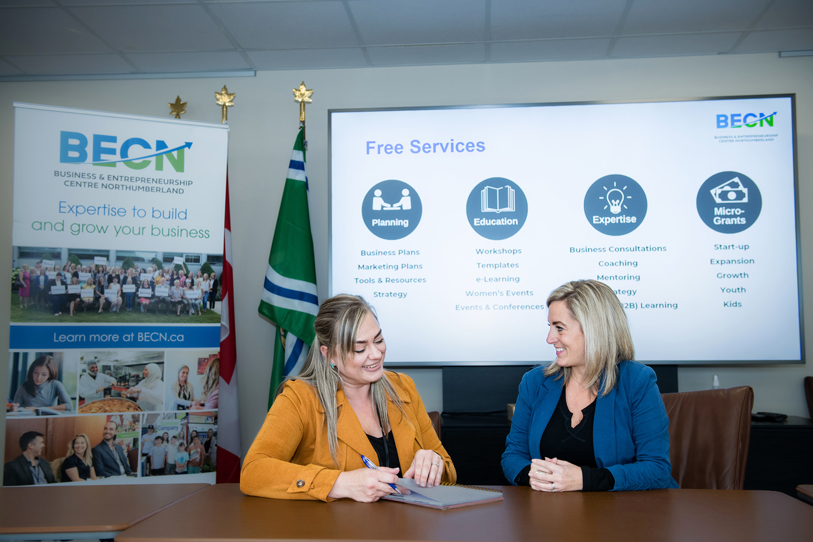 BECN staff member working with a client while sitting at a table.