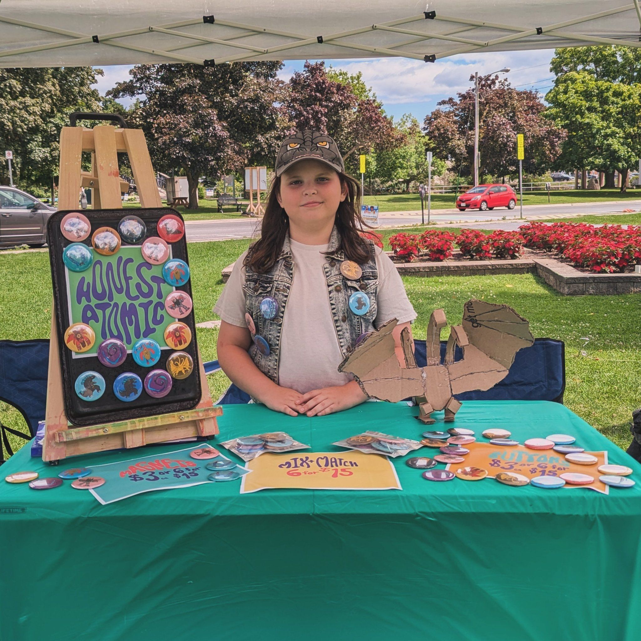 Young girl sells artwork and buttons at Cobourg Farmer's Market